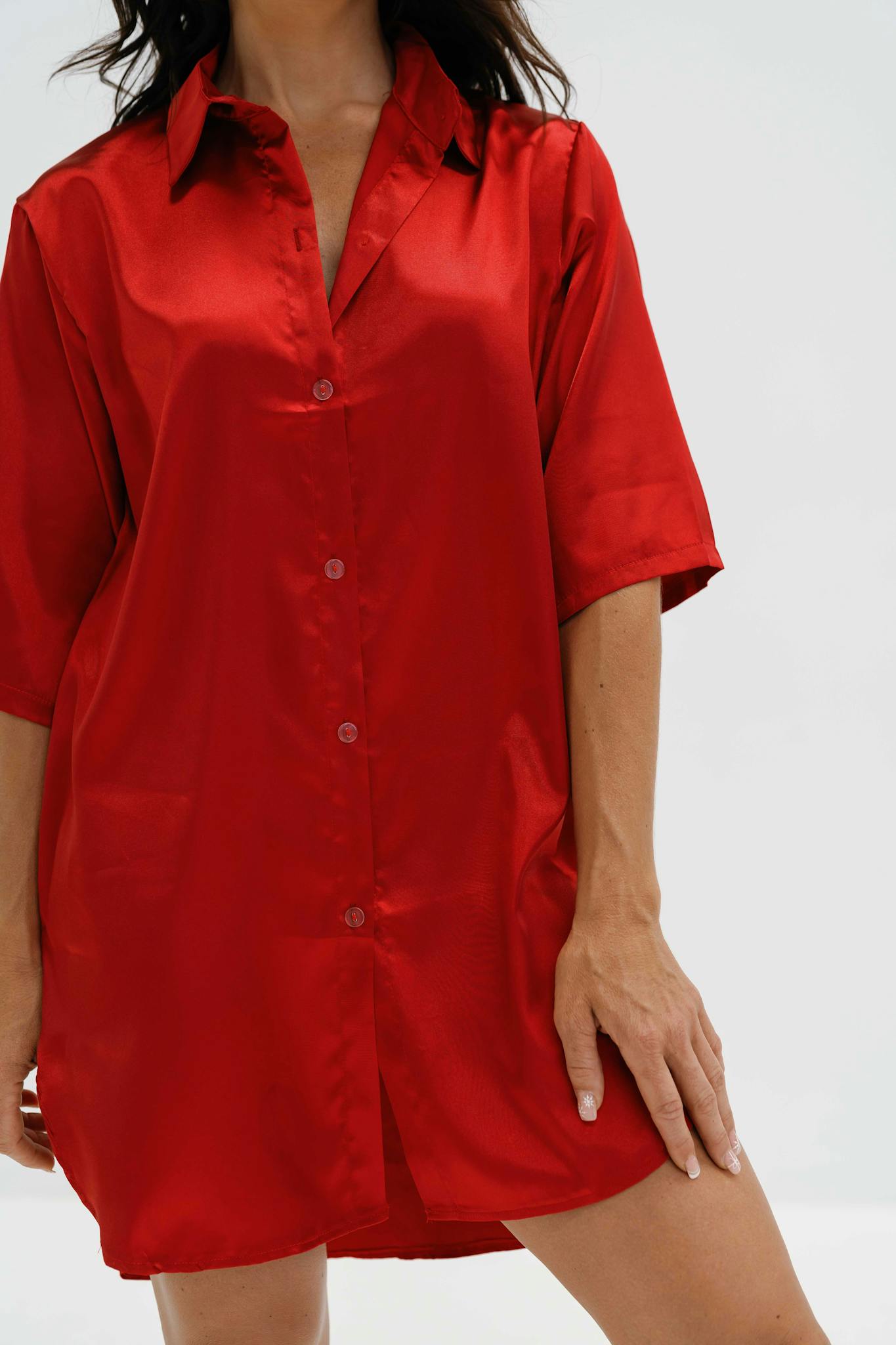 A woman wearing a stylish crimson red satin shirt, capturing elegance and fashion.
